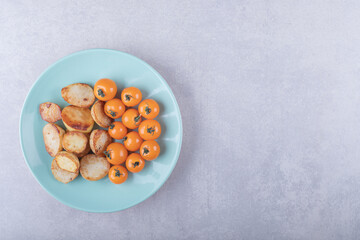 Fried potatoes and cherry tomatoes on blue plate