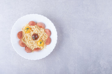 Spaghetti with roasted sausages and tomatoes in white bowl