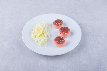 Boiled sausages and grated cheese on white plate