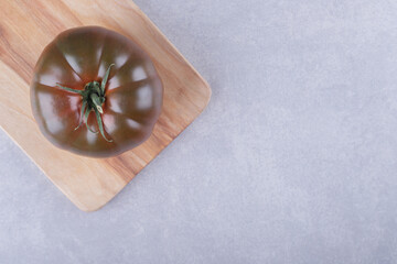 Fresh ripe tomato on wooden board