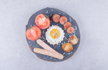 Boiled and fried sausages with egg on wood piece