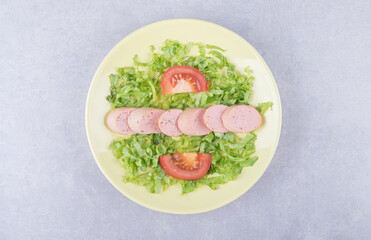 Sliced sausages and tomatoes on yellow plate