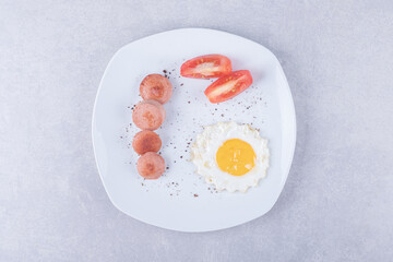 Sliced sausages and egg on white plate
