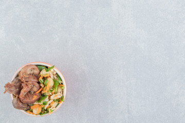 A bowl with fried chicken legs and vegetable salad