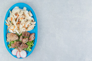 A wooden board with fried meat and vegetable salad