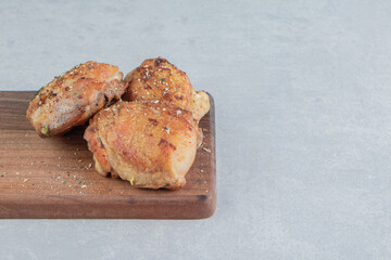 A wooden board with fried chicken meat with relish