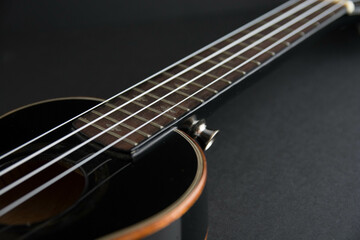 Fototapeta na wymiar Close up ukulele isolated on dark background. Copy text.
