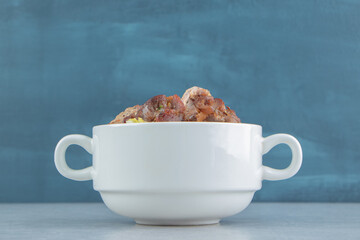 A white bowl with fried delicious meat