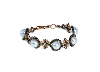 Women's bracelet, woven of gold white beads and pearls. Isolated on a white background.
