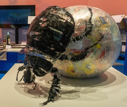 Closeup shot of a composition with a giant dung beetle and a huge ball