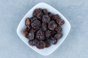 A bowl of dried cherry, on the marble background
