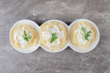Spaghetti, yogurt and green vegetable on the plate , on the marble background