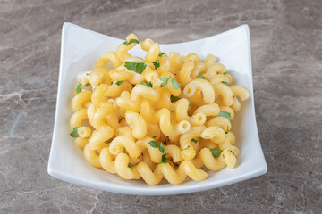 Toothsome pasta with green vegetables , on the marble background