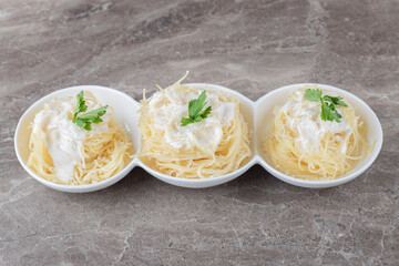 Spaghetti, yogurt and green vegetable on the plate , on the marble background