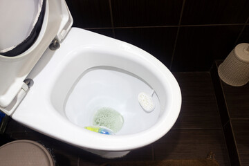 clean toilet bowl with air freshener on restroom close-up