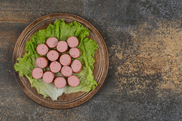 Fried sliced sausages on wooden board