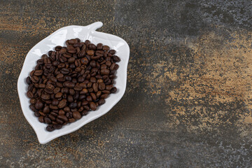 Roasted coffee beans on leaf shaped plate