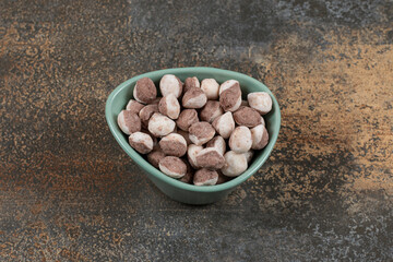 Tasty brown candies in blue bowl