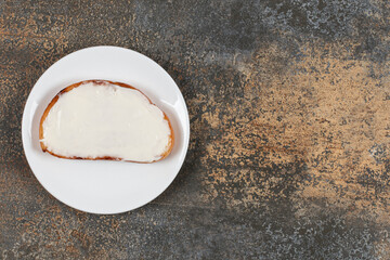 Slice of toast with sour cream on white plate