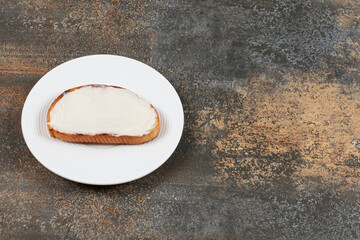 Slice of toast with sour cream on white plate