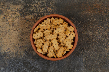 Tasty baked crackers in ceramic bowl