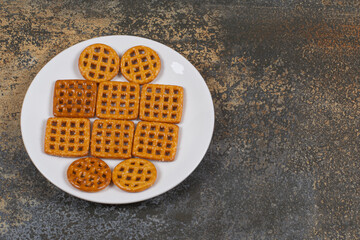 Assortment of salted crackers on white plate