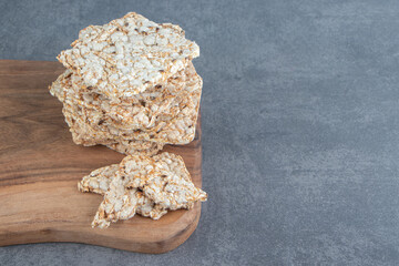 A wooden board of crispy square rice waffles