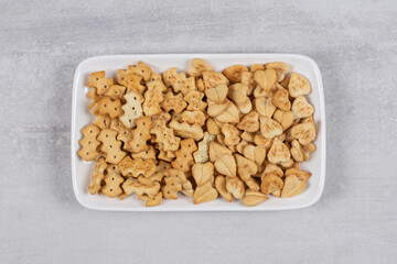 Plate of salted crackers on stone background