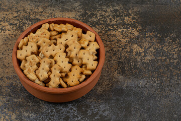 Tasty baked crackers in ceramic bowl