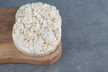 A wooden cutting board with puffed rice bread
