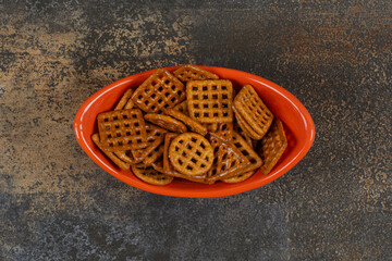 Bowl of salted crackers on marble background