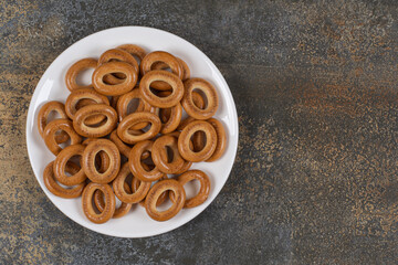 Plate of salted crackers on marble background