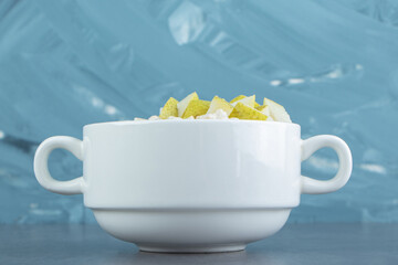 A white plate of oatmeal porridge with slices of pear