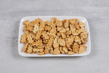 Plate of salted crackers on stone background
