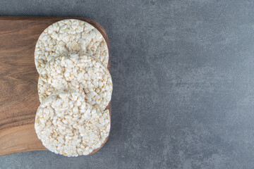 A wooden cutting board with puffed rice bread