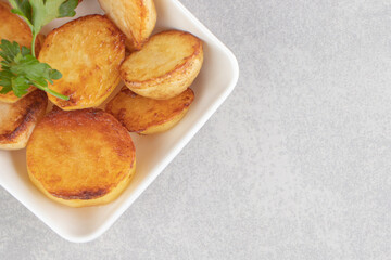 Slices of fried potatoes on white plate