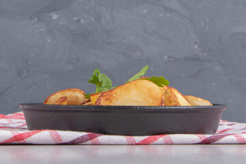 Slices of fried potatoes on black plate