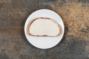 Slice of toast with sour cream on white plate