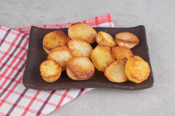 Slices of fried potatoes on brown plate