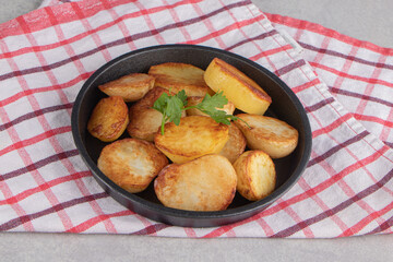 Slices of fried potatoes on black plate