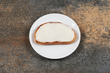 Slice of toast with sour cream on white plate