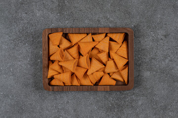 Delicious crunchy chips on wooden plate