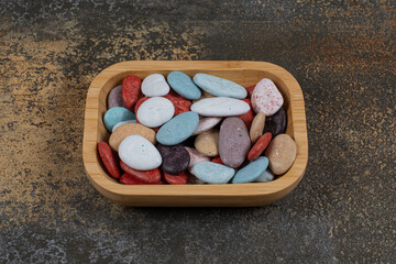 Oval shaped stone candies on wooden plate