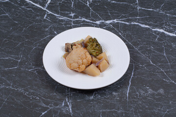 Close up photo of marinated vegetables on white plate