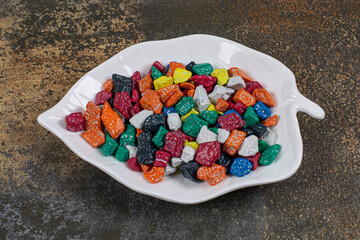 Multicolored stone candies on leaf shaped plate