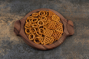Various salty crackers on wooden board