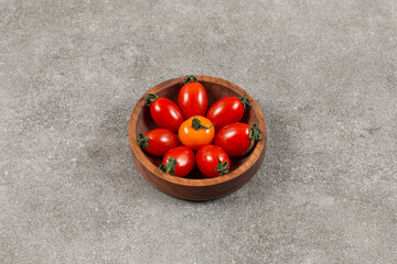 Top view of fresh cherry tomatoes in wooden bowl