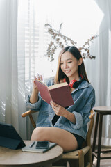 Asian female college student reading a book in a cafe girl working in a cafe