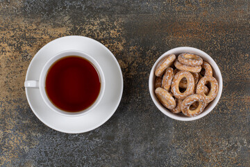 Bowl of salty crackers and cup of tea on marble background