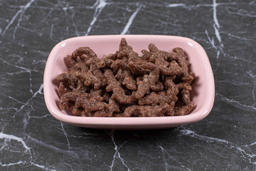 Chocolate cereal flakes in pink bowl